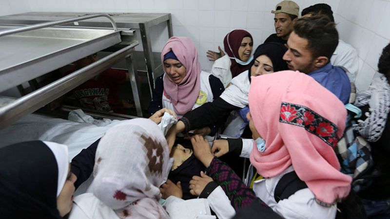 Colegas de la enfermera palestina Razan Ashraf Najjar junto a su cuerpo en la morgue de un hospital en el sur de la Franja de Gaza